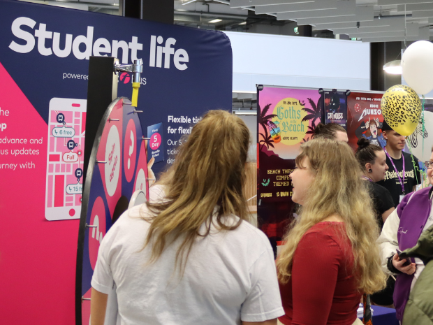 Image of students looking at an advertising board at City of Glasgow College Freshers Week.